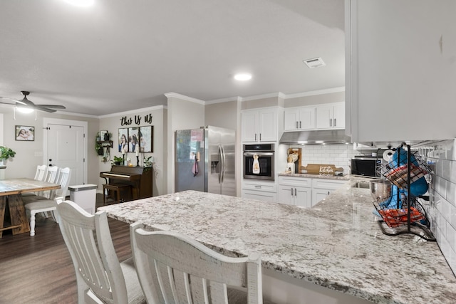 3101 Lax St, Newport, AR 72112 - kitchen with appliances with stainless steel finishes, under cabinet range hood, ornamental molding, a peninsula, and light stone counters