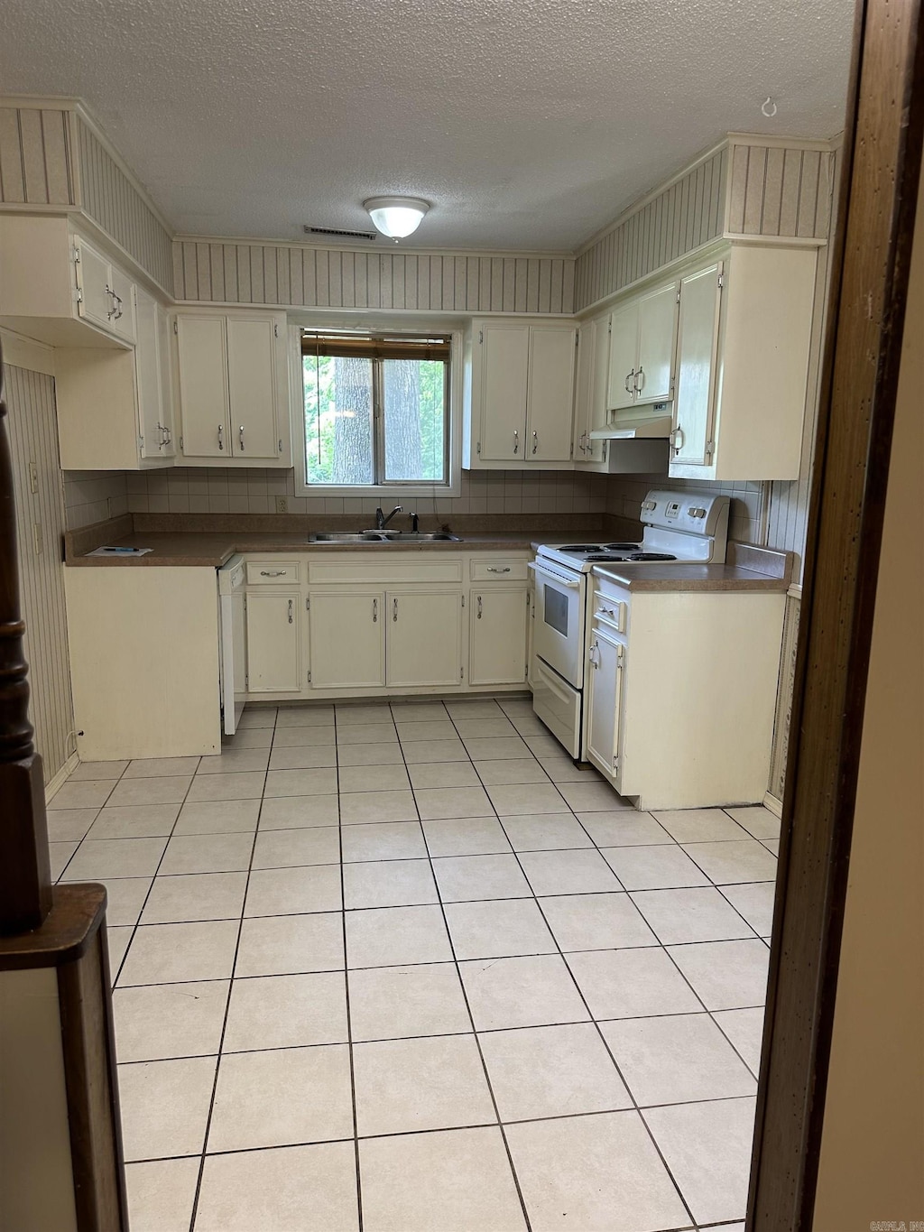 51 Sfc 445, Forrest City, AR 72335 - kitchen featuring white appliances, a sink, a textured ceiling, under cabinet range hood, and dark countertops