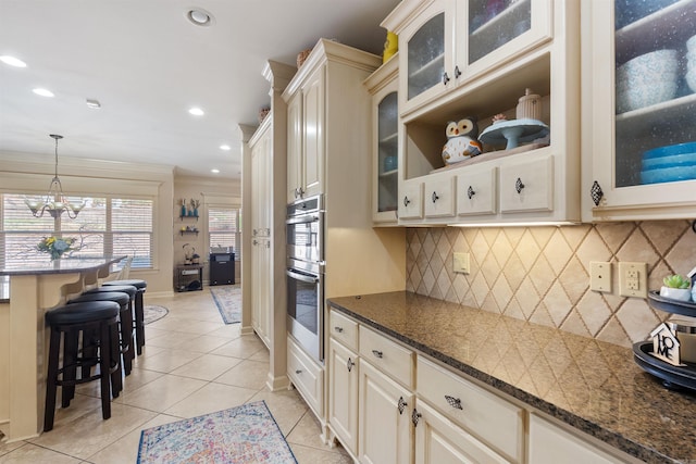 26 Jacob Pl, Little Rock, AR 72211 - kitchen featuring a breakfast bar area, light tile patterned floors, recessed lighting, pendant lighting, and double oven