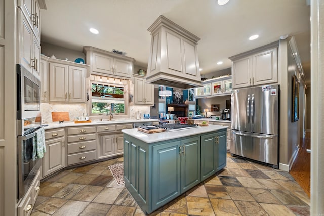 kitchen featuring stainless steel appliances, stone tile floors, light countertops, and recessed lighting