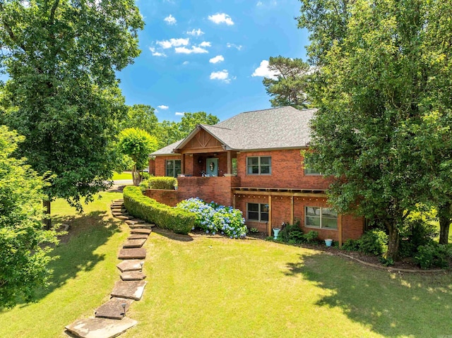 view of front of house featuring brick siding and a front lawn
