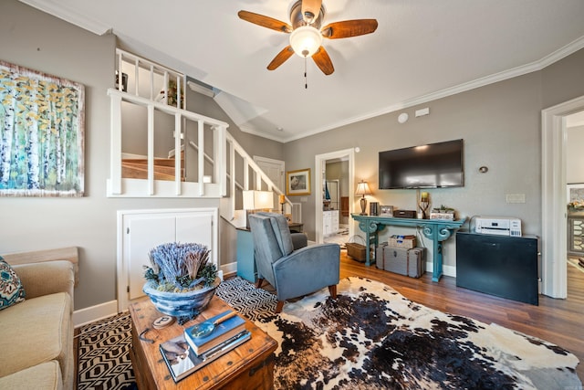 living room with ceiling fan, wood finished floors, ornamental molding, stairway, and baseboards