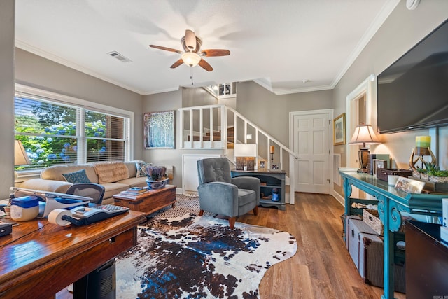 living room featuring stairway, ceiling fan, ornamental molding, wood finished floors, and baseboards