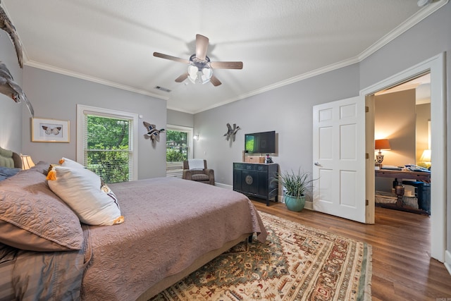 bedroom featuring wood finished floors, crown molding, and ceiling fan