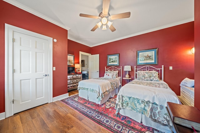 bedroom featuring wood finished floors, ornamental molding, baseboards, and ceiling fan