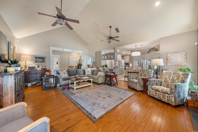 living area featuring a ceiling fan, high vaulted ceiling, light wood finished floors, and recessed lighting