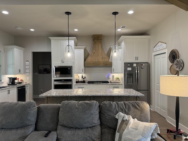 106 Harmony Village Dr, Haskell, AR 72015 - kitchen featuring stainless steel appliances, premium range hood, white cabinetry, open floor plan, and decorative backsplash