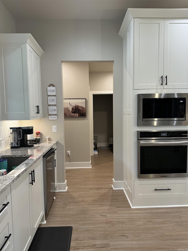 106 Harmony Village Dr, Haskell, AR 72015 - kitchen with appliances with stainless steel finishes, baseboards, light wood-type flooring, white cabinets, and light stone counters