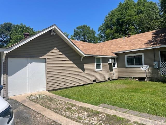 view of property exterior with a garage and a lawn
