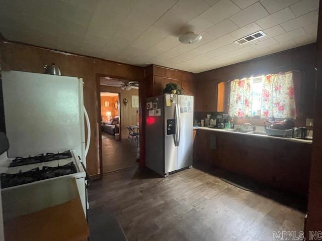 kitchen with white appliances, light wood-type flooring, ceiling fan, and brown cabinetry