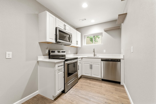 201 Sunset St, Hot Springs, AR 71913 - kitchen featuring stainless steel appliances, a sink, white cabinets, light wood-style flooring, and light countertops