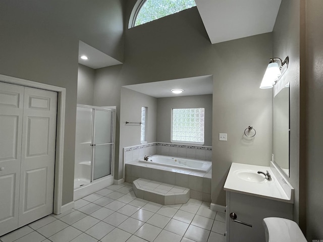 bathroom featuring vanity, a garden tub, a stall shower, baseboards, and tile patterned flooring