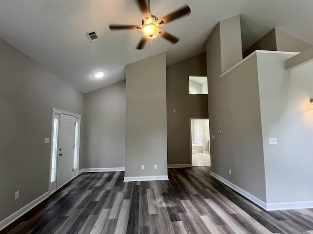 spare room featuring high vaulted ceiling, ceiling fan, dark wood-style flooring, and baseboards
