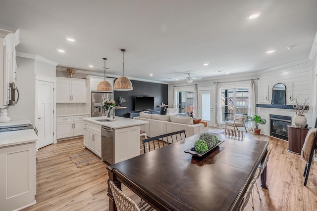118 Lydia Dr, Maumelle, AR 72113 - dining area featuring ornamental molding, recessed lighting, ceiling fan, a glass covered fireplace, and light wood-style flooring
