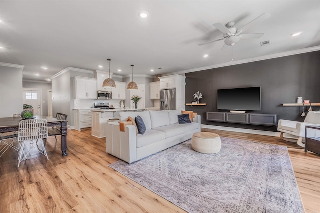 118 Lydia Dr, Maumelle, AR 72113 - living area featuring a ceiling fan, ornamental molding, recessed lighting, and light wood-style flooring