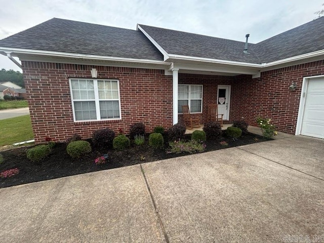 13815 Carrington Place Dr, Alexander, AR 72002 - entrance to property featuring brick siding, roof with shingles, concrete driveway, and a garage