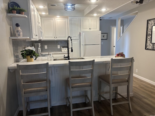 135 Hillview Dr Unit 19, Fairfield Bay, AR 72088 - kitchen with white appliances, a peninsula, open shelves, white cabinetry, and a raised ceiling