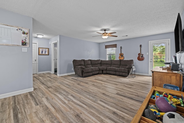 31 D Plummer Rd, Lonoke, AR 72023 - living room featuring light wood-style floors, a textured ceiling, ceiling fan, plenty of natural light, and baseboards