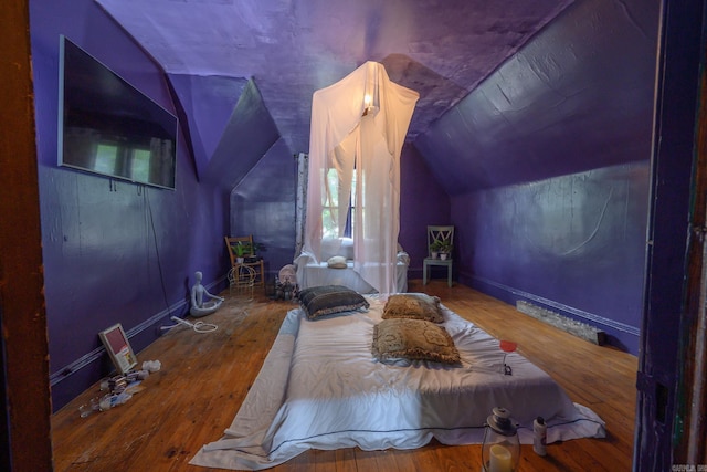 1107 Magnolia, Mena, AR 71953 - bedroom with wood-type flooring, lofted ceiling, multiple windows, and baseboards