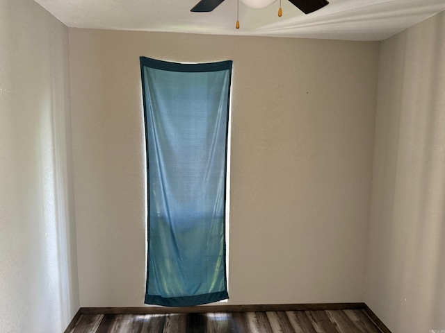 211 Turner St, Mena, AR 71953 - empty room with ceiling fan, dark wood-style flooring, and baseboards