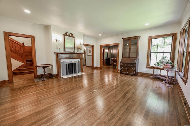 837 Maple St, Camden, AR 71701 - living area featuring stairway, wood finished floors, baseboards, crown molding, and a fireplace with raised hearth