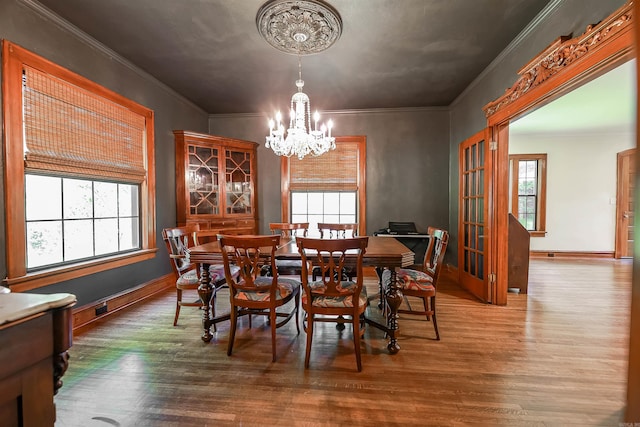 837 Maple St, Camden, AR 71701 - dining space with a chandelier, wood finished floors, crown molding, and baseboards
