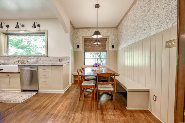 837 Maple St, Camden, AR 71701 - dining area featuring light wood-style flooring, wainscoting, and wallpapered walls