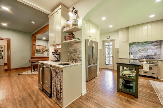 837 Maple St, Camden, AR 71701 - kitchen featuring stainless steel appliances, open shelves, a sink, light wood-style floors, and recessed lighting