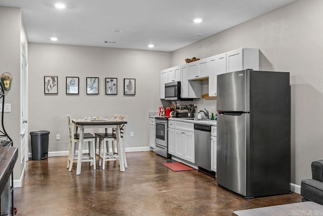 1912A5 Central Blvd, Bull Shoals, AR 72619 - kitchen featuring appliances with stainless steel finishes, light countertops, finished concrete floors, recessed lighting, and white cabinets