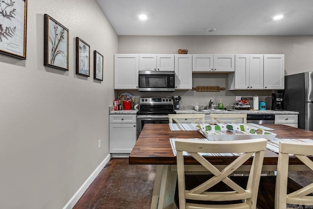 1912A5 Central Blvd, Bull Shoals, AR 72619 - kitchen with appliances with stainless steel finishes, wooden counters, baseboards, concrete flooring, and a sink