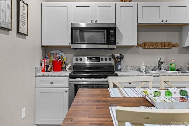 1912A5 Central Blvd, Bull Shoals, AR 72619 - kitchen featuring appliances with stainless steel finishes, butcher block countertops, white cabinets, and a sink
