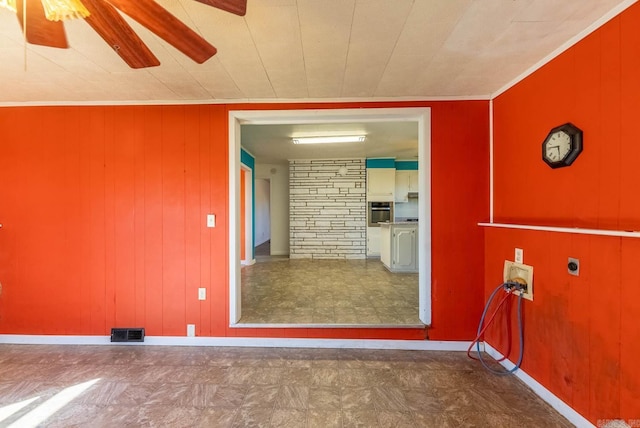 laundry area featuring cabinet space, tile patterned floors, wood walls, and a ceiling fan