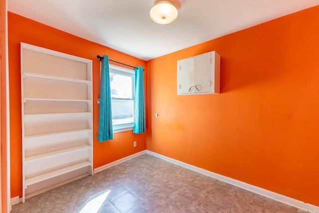unfurnished room with baseboards