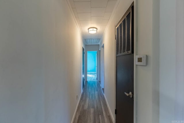 hall featuring ornamental molding, wood finished floors, and baseboards