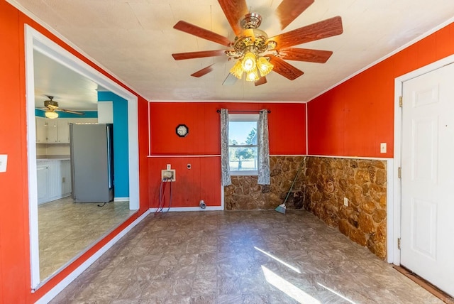 unfurnished room featuring ceiling fan, ornamental molding, wainscoting, and tile patterned floors