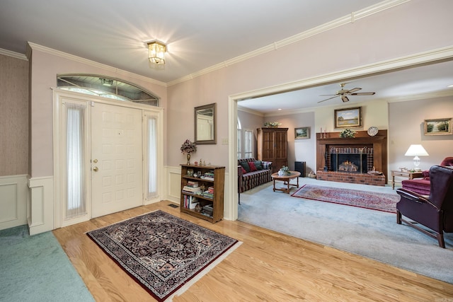 16 Masters Place Dr, Maumelle, AR 72113 - entrance foyer featuring wood finished floors, ornamental molding, wainscoting, a brick fireplace, and a ceiling fan