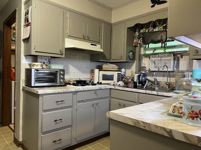 1702 E Spring Dr, Horseshoe Bend, AR 72512 - kitchen with gray cabinetry, under cabinet range hood, backsplash, white appliances, and light countertops
