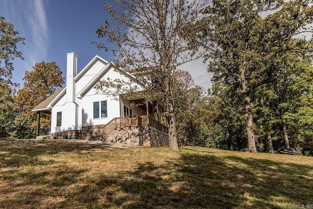 38 Oak Ridge Dr, Gepp, AR 72538 - view of side of property featuring a chimney, a lawn, board and batten siding, and stairway