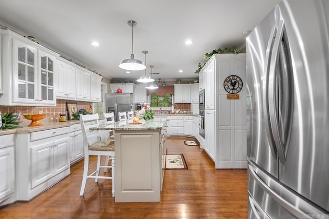 111 Country Oaks Dr, Malvern, AR 72104 - kitchen featuring freestanding refrigerator, stainless steel fridge, white cabinets, a kitchen bar, and recessed lighting
