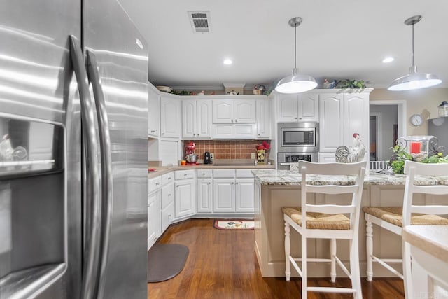 111 Country Oaks Dr, Malvern, AR 72104 - kitchen with stainless steel appliances, white cabinets, a kitchen bar, recessed lighting, and ornamental molding