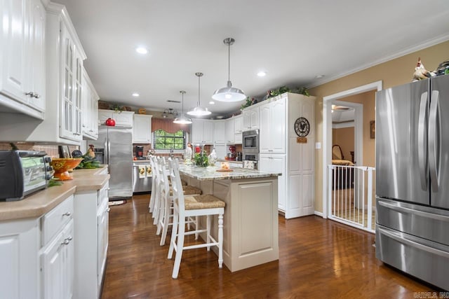 111 Country Oaks Dr, Malvern, AR 72104 - kitchen featuring appliances with stainless steel finishes, white cabinets, dark wood-style flooring, a center island, and crown molding
