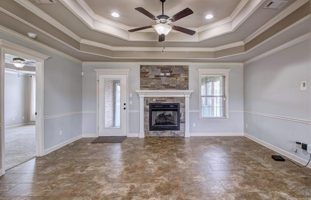 68 Smarty Jones Cir, Austin, AR 72007 - unfurnished living room with ceiling fan, a tray ceiling, a stone fireplace, ornamental molding, and baseboards
