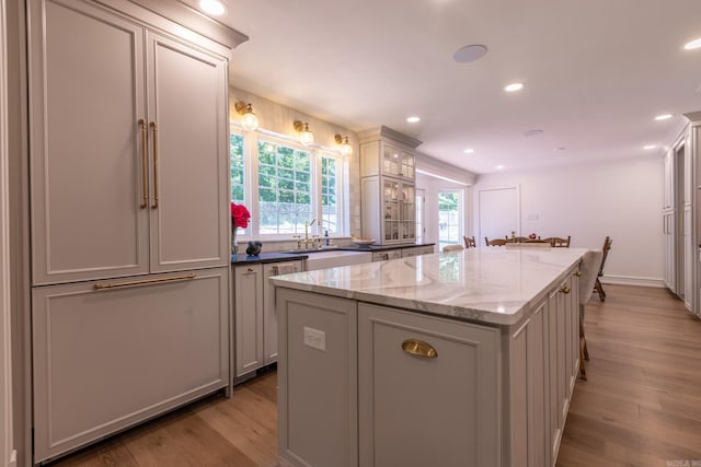 40 Tennyson Ct, North Little Rock, AR 72116 - kitchen featuring a kitchen island, light wood-type flooring, a sink, light stone countertops, and recessed lighting