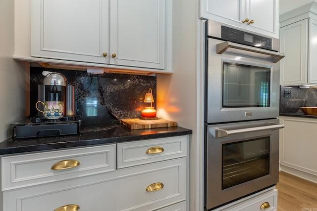 40 Tennyson Ct, North Little Rock, AR 72116 - kitchen featuring stainless steel double oven, tasteful backsplash, wine cooler, white cabinets, and light wood finished floors
