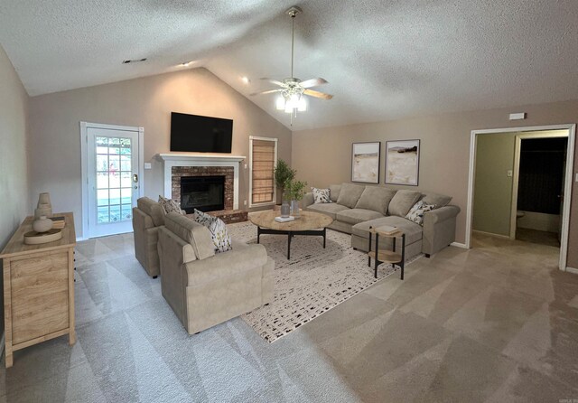 1828 Dove Dr, Benton, AR 72015 - carpeted living room featuring a ceiling fan, vaulted ceiling, a textured ceiling, a fireplace, and baseboards