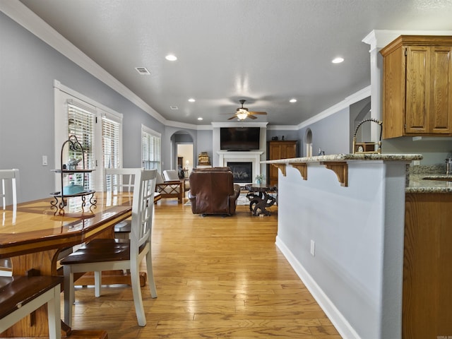 57 Excelso Way, Hot Springs Village, AR 71909 - dining area featuring ceiling fan, recessed lighting, light wood finished floors, ornamental molding, and a fireplace