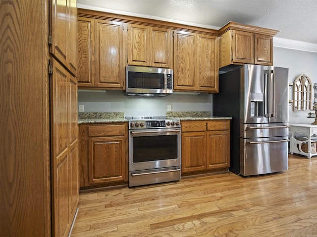 57 Excelso Way, Hot Springs Village, AR 71909 - kitchen featuring appliances with stainless steel finishes, crown molding, brown cabinets, and light wood finished floors