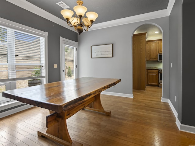 57 Excelso Way, Hot Springs Village, AR 71909 - dining area with a chandelier, baseboards, light wood finished floors, arched walkways, and crown molding
