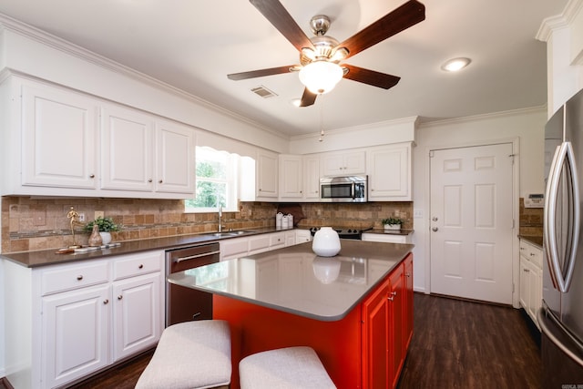 69 Quail Valley Rd, Sherwood, AR 72120 - kitchen with appliances with stainless steel finishes, a sink, ceiling fan, backsplash, and white cabinetry