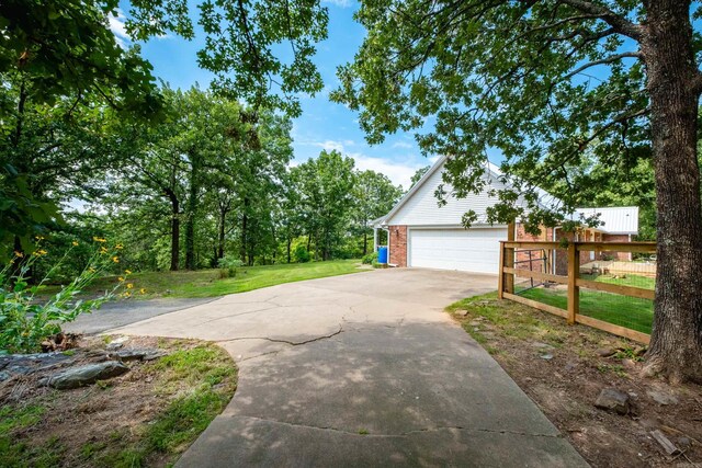 69 Quail Valley Rd, Sherwood, AR 72120 - view of property exterior with concrete driveway, an attached garage, and brick siding